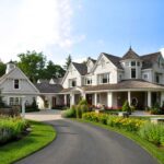 A large white house with a driveway in front of it.