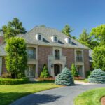 A large brick house with a driveway in front of it.