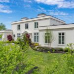 A large white house with a garden in front of it.