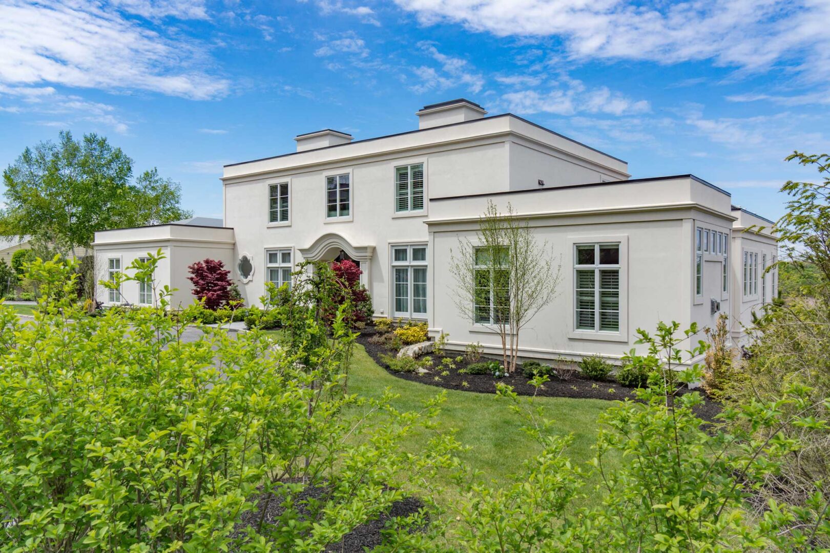 A large white house with a garden in front of it.