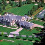 A large mansion with many trees and grass