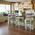 A kitchen with wooden floors and white cabinets.