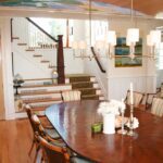 A dining room table with chairs and a vase of flowers.