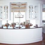 A kitchen with white cabinets and a large island.