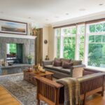 A living room with two large windows and a fireplace.