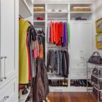 A walk in closet with many different types of clothes.