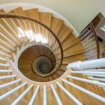 A spiral staircase with wooden steps and white railings.