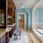 A bathroom with blue walls and white fixtures.