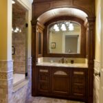 A bathroom with a large mirror and wooden cabinets.