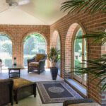 A living room with arched windows and brick walls.