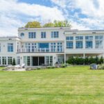 A large white house with a lawn in front of it.