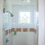 A bathroom with a shower and window in it