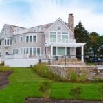 A large house with a lot of grass on the front lawn.