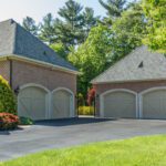 Two garages in a residential neighborhood with trees.