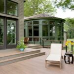 A deck with a chair and flowers on the patio.