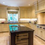 A kitchen with white cabinets and black counter tops.