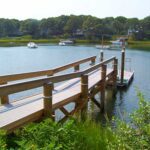 A wooden dock with boats in the water.