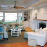 A living room with white furniture and wooden floors.