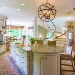 A kitchen with a large island and a staircase.