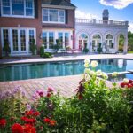 A large pool surrounded by flowers and brick.