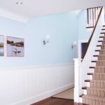 A staircase with white railings and blue walls.