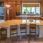 A kitchen with a large island and wooden cabinets.