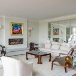 A living room with white furniture and a fireplace.