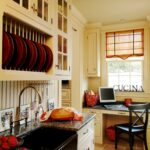 A kitchen with a sink, microwave and laptop.