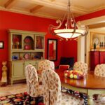 A dining room with red walls and a wooden table.