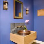 A bathroom with blue walls and a wooden vanity.