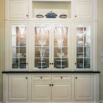 A large white cabinet with glass doors and drawers.