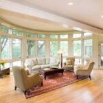 A living room with hard wood floors and large windows.