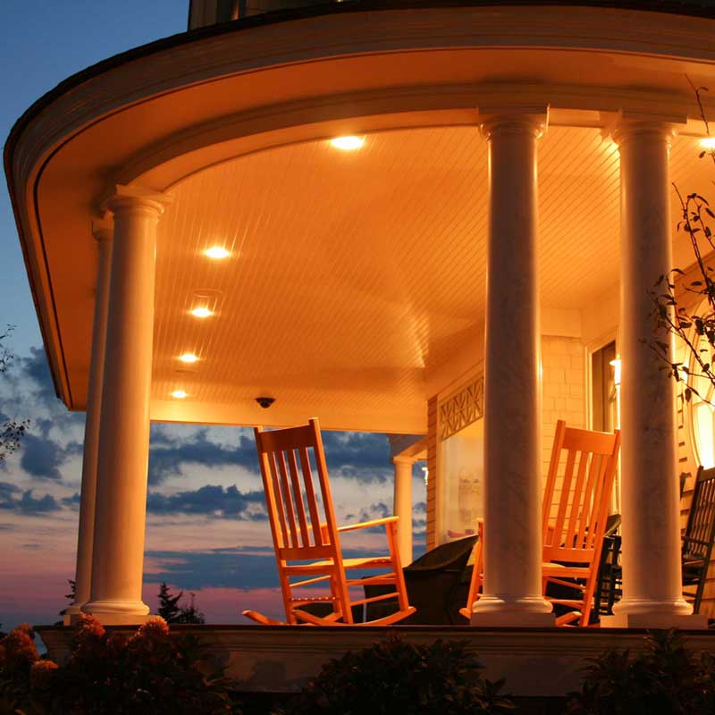 A porch with two rocking chairs and a table.