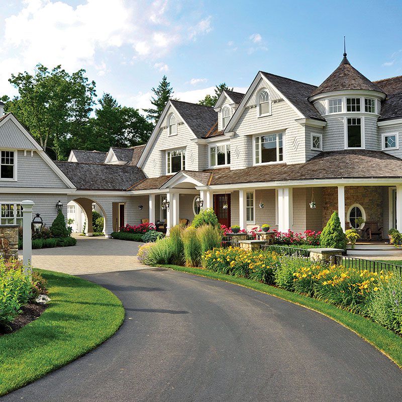 A large white house with a driveway in front of it.