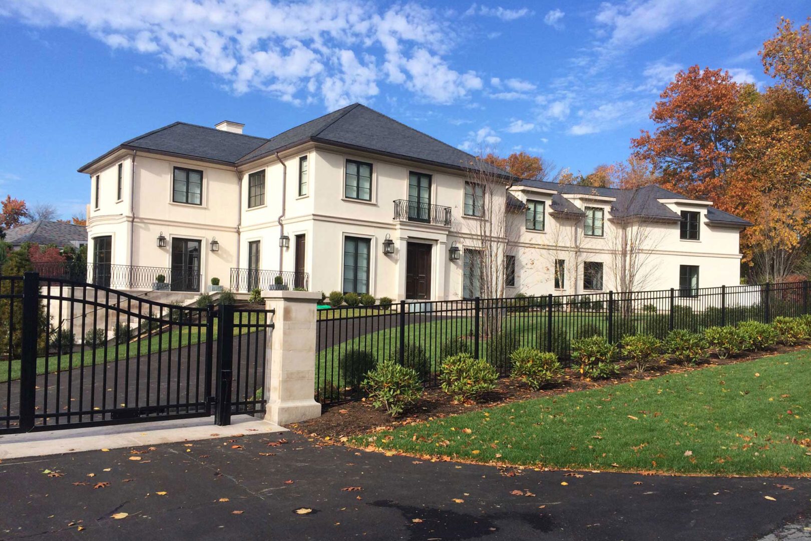 A large white house with a black gate.