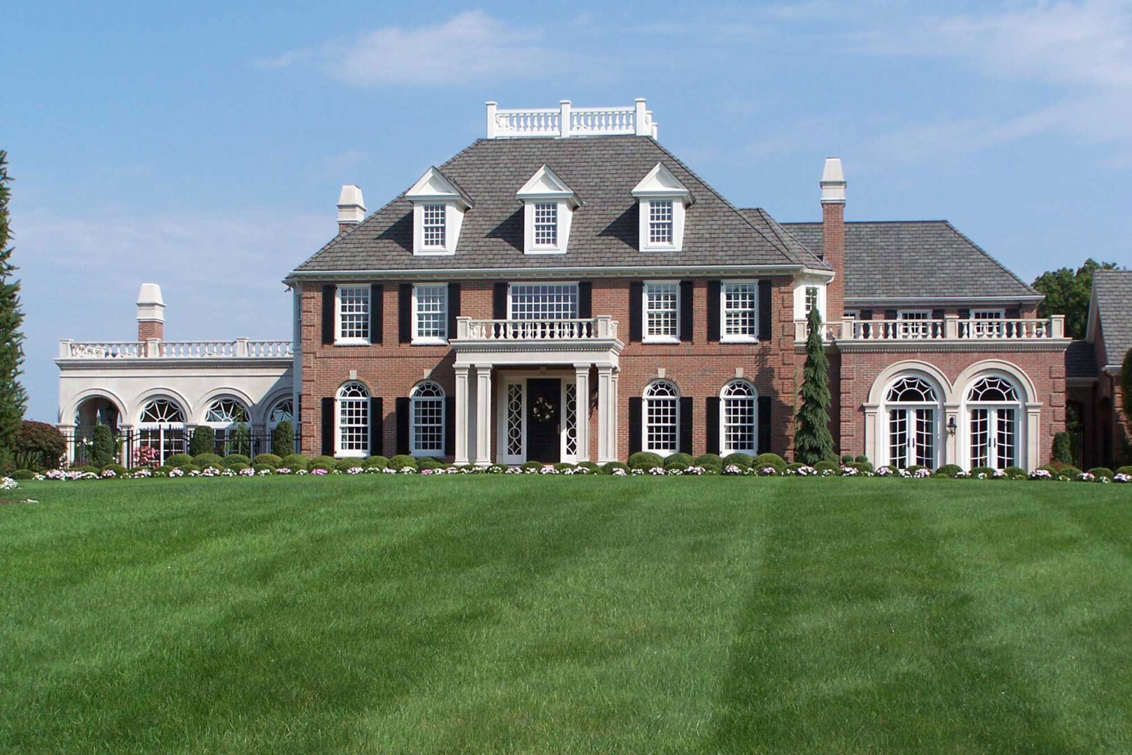 A large brick house with a lawn in front of it.