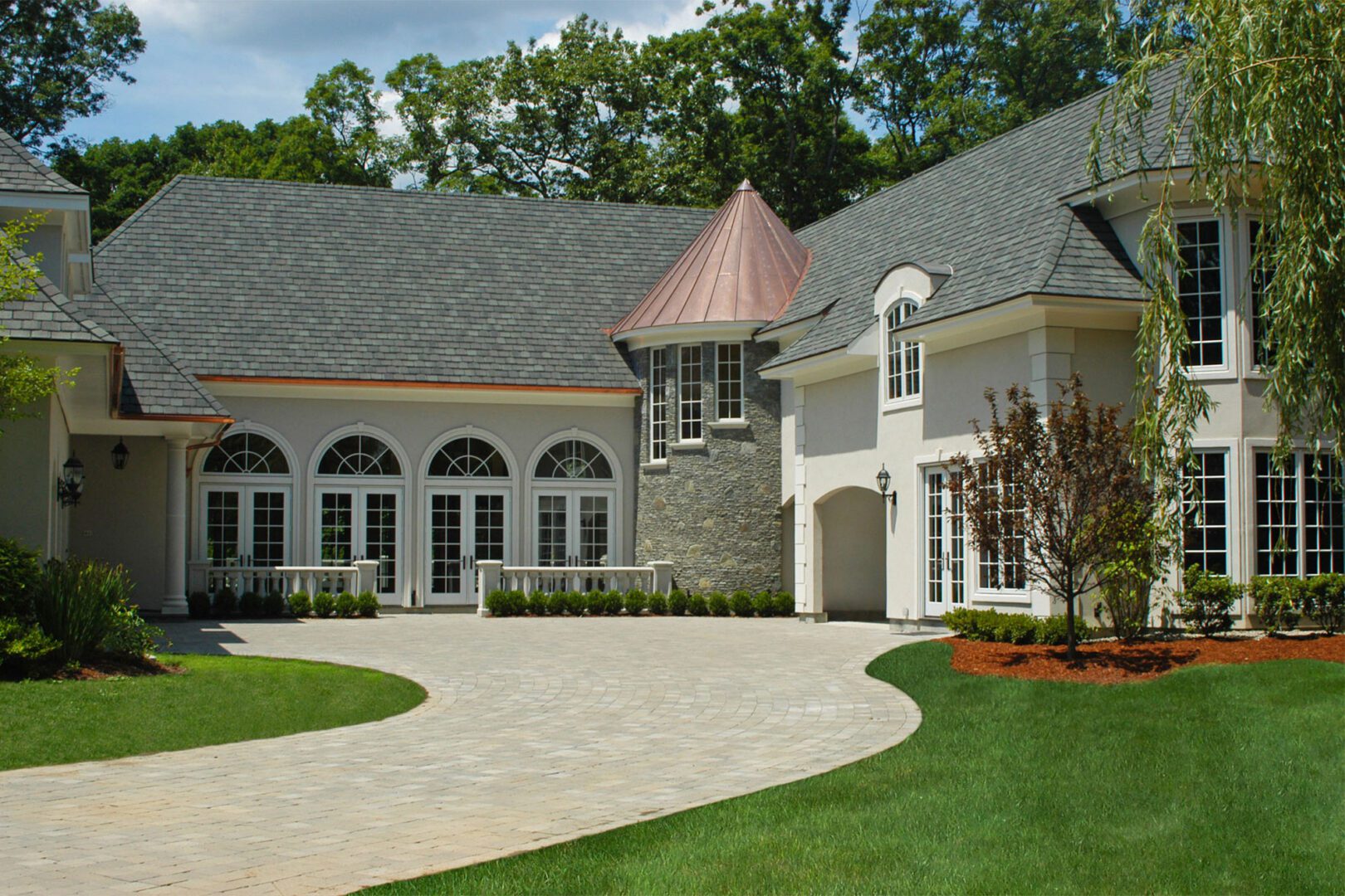 A large house with a big driveway and lots of windows.