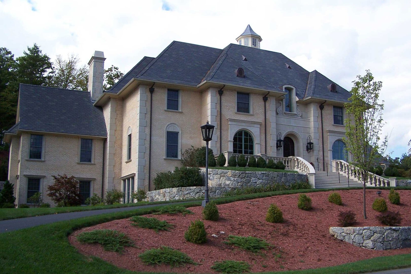 A large house with a driveway and bushes