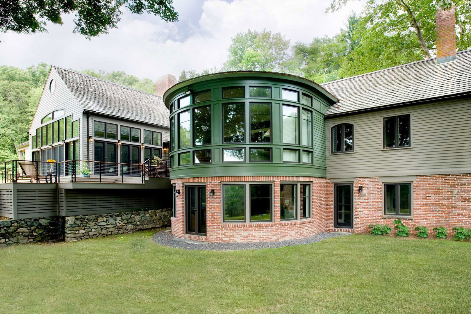 A large house with green windows and brick walls.