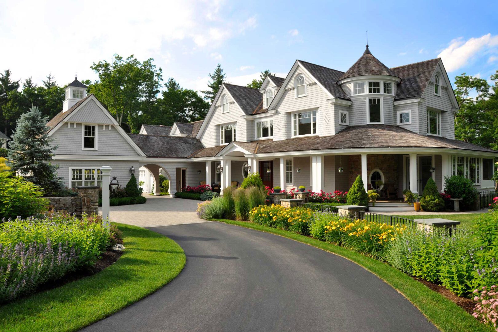 A large white house with a driveway in front of it.