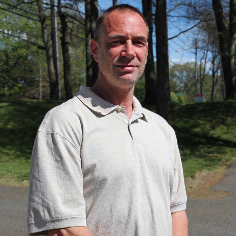 A man standing in front of some trees